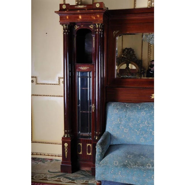 Mahogany on solid wood. Architecturally designed body flanked by solid columns. Facet-ground mirror and glass panes....