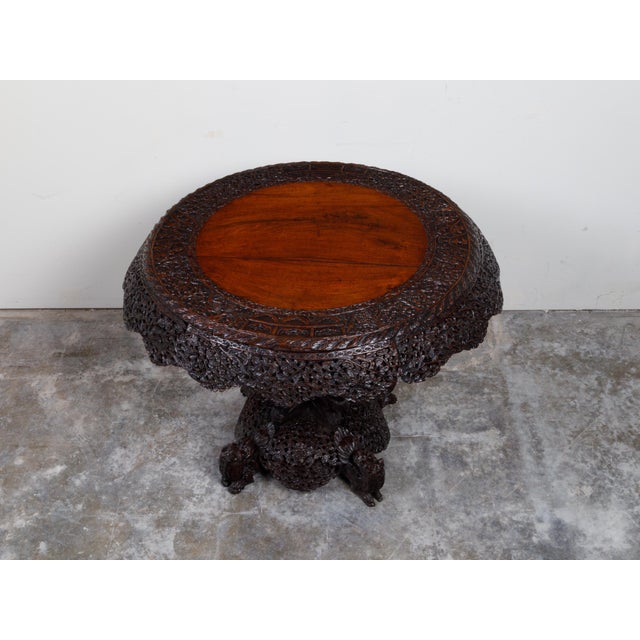 A Burmese hand-carved side table from the 19th century, with mythical animals and foliage. Created in Burma during the...