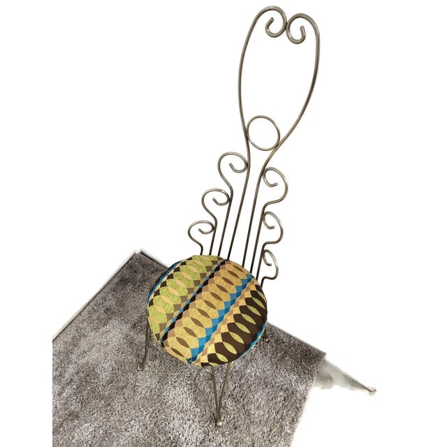 A dramatic chrome wire lyre-back accent chair from the 1960s American Hollywood Regency period — 48 inches tall, with an...