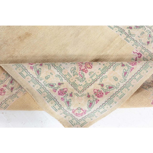 An antique Indian hand-knotted wool rug circa 1935 features beige medallion shaped open field with stylized decorative...