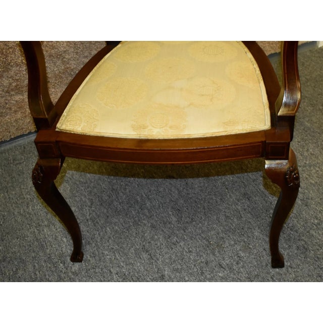 Antique (1900s) Arm Chair has an Edwardian Style. The Chair is Made of Wood. Mahogany. Inlaid Back Panel. The Seat has...