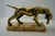 A striking mid-century brass sculpture depicting a pointer or retriever hunting dog proudly clutching a game bird in its...
