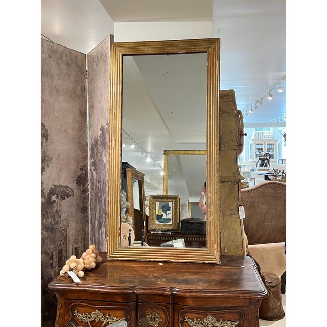 An elegant 19th century French Louis XVI mirror featuring a finely carved giltwood frame with classic neoclassical...