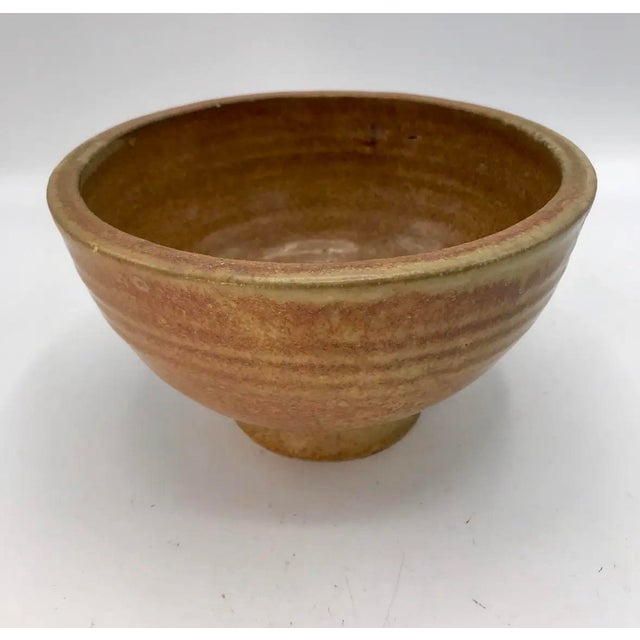 A beautifully thrown vintage stoneware bowl with a substantial rounded rim, high ring foot, and pronounced horizontal...
