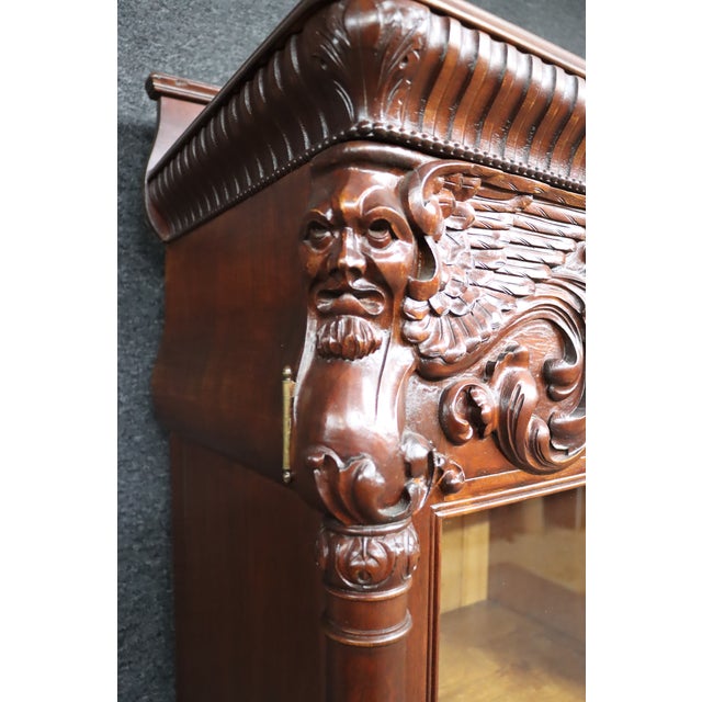 An impressive attributed R.J. Horner mahogany breakfront bookcase secretary featuring exceptional high-relief carved...