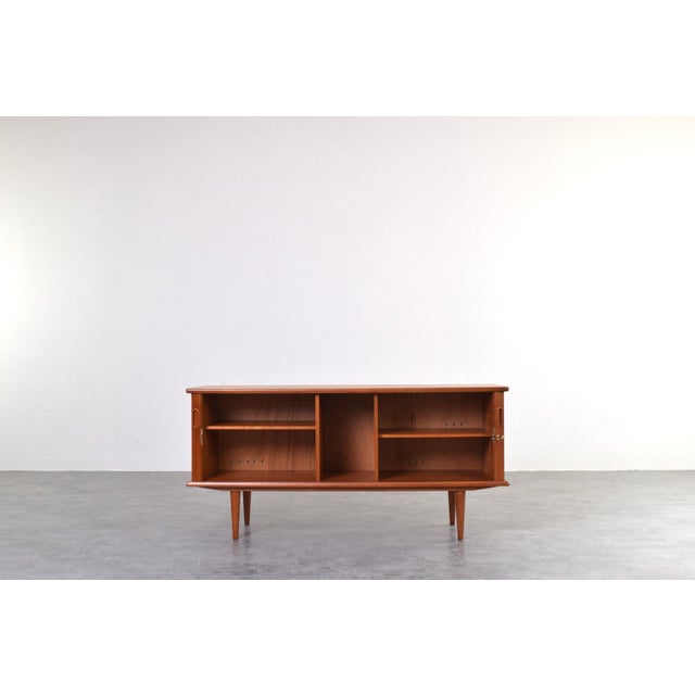 Danish teak sideboard created in the Scandinavian Modern / Mid-Century Modern style. This piece perfectly reflects why...