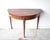 An antique French demilune card table in the neoclassical Sheraton style, with an inlaid marquetry sunburst top and...