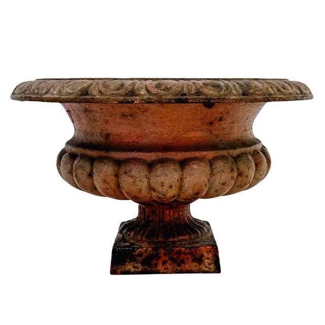 Pair of antique cast iron planters designed in the classic Campana (bell) shape and featuring a heavily weathered,...