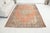 This is a vintage Turkish Oushak rug from the Mid 20th Century. The piece was hand-knotted.