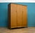 A well-proportioned mid-century triple wardrobe by Alfred Cox, finished in richly figured walnut and raised on tapered...