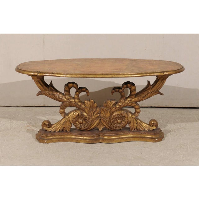 A Mid-19th century Italian gilded wood coffee table. This Italian coffee table features a gilded base made of richly...