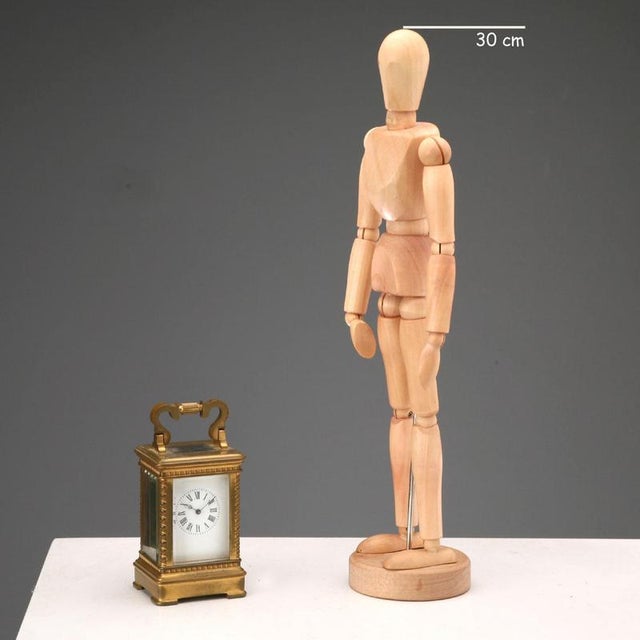 Miniature travel clock in gilded bronze and glass. Visible movement. Enamelled metal dial with Roman numeral hour markers....