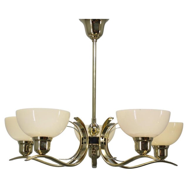 This refined art deco chandelier originates from czechoslovakia in the 1930s and features a polished brass structure...