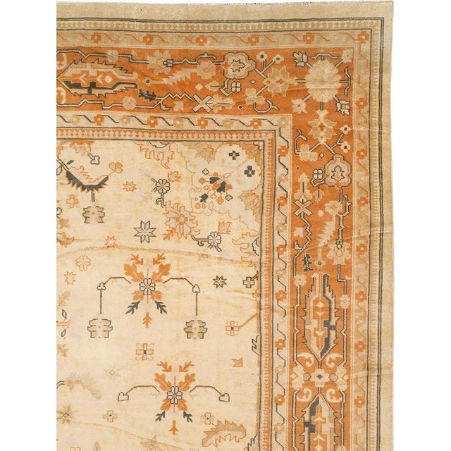 This Mid-20th century Turkish Anatolian large carpet presents an elegant floral composition across a warm ivory field. A...