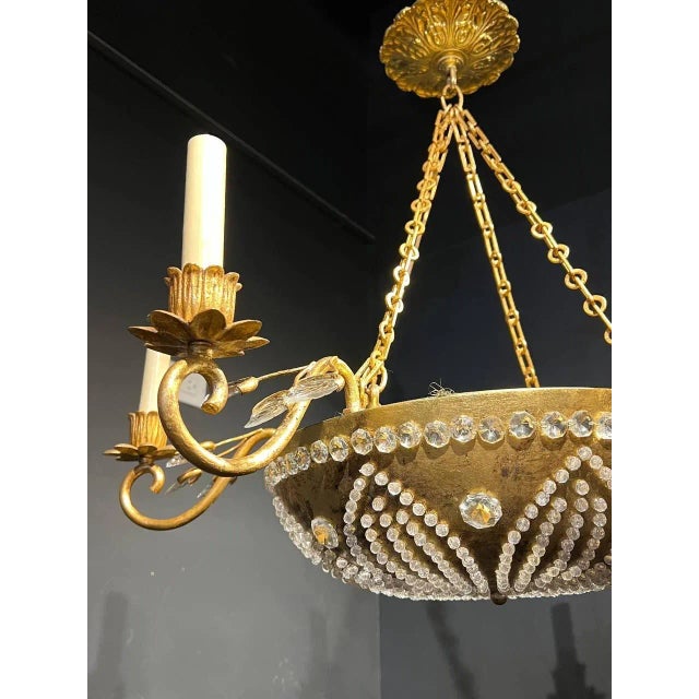 A circa 1940’s French Bagues light fixture with beaded crystals and interior lights
