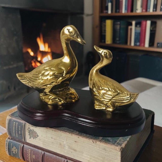 Mid Century brass duck figurines mounted on wood base. Great bookcase and tabletop decor. Measures 6” w x 3” d x 4.5”h.
