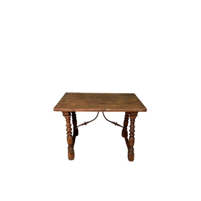A 19th-century walnut table with a single-plank top, showcasing the continuity and richness of the natural grain. The...