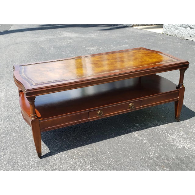 A well kept 1958 Hollywood Regency Mahogany and Tooled Leather Top and Gilt Stencil Two tier Coffee Table on original...