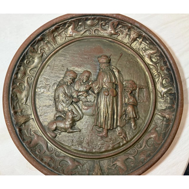 The large antique ornate bronze patinated cast iron relief wall plaque featuring a figural design in high relief is a...