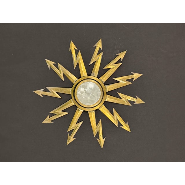 Wall mirror. Made of brass and mirror. with a diameter of 63 cm, the central mirror measures 13 cm in diameter and has a...