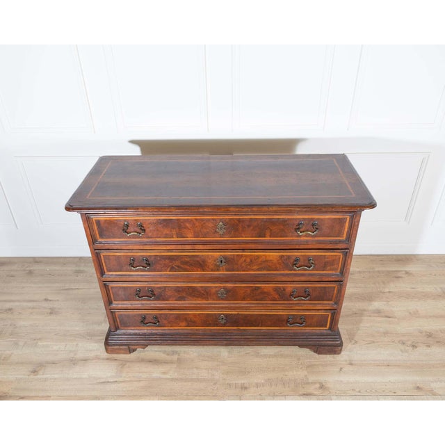 An exceptional early 18th-century chest of drawers from the Emilia region of Italy, crafted in solid walnut and delicately...