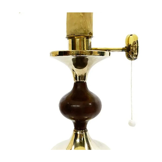 A brass and wooden stacked stem floor lamp. With a candle as holder of the fitting. The candle looks and feels like an...