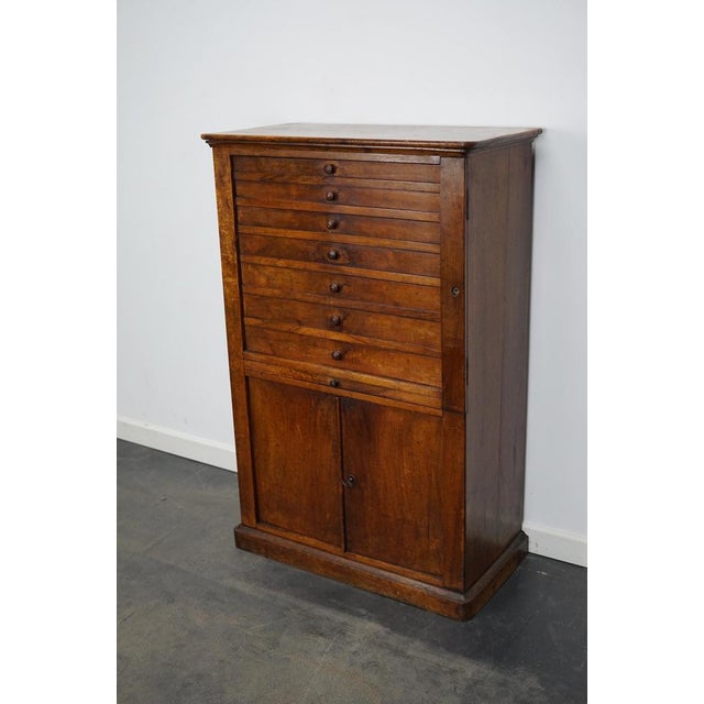This clock / watchmakers cabinet was designed and made in the early 20th century in France. It features 7 walnut fronted...