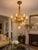 An elegant antique Louis XVI Revival chandelier featuring a richly carved giltwood frame, five scrolling candle arms, and...