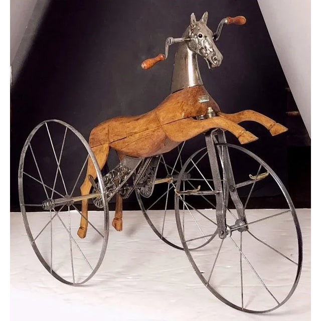 A fine French velocipede or child's toy horse tricycle from the 19th century, featuring a body of carved wood with brushed...