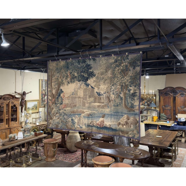 This exceptional antique French Aubusson tapestry was handwoven circa 1780 and presents a romantic verdure landscape...