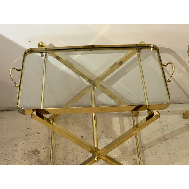 Pair of vintage Campaign style tables in polished brass. Trays are removable and tables stand without the trays, or can...