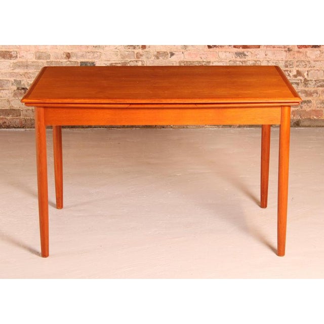 Danish Mid Century extending teak dining table, circa 1970s. Two pull-out extension leaves stored underneath. Extends to...