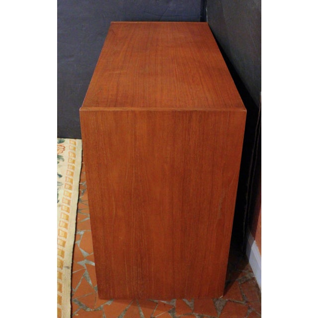 Circa 1960s Mid-Century Modern small 4-drawer chest, English. Smartly styled with molded finger pulls; teak. Sides extend...