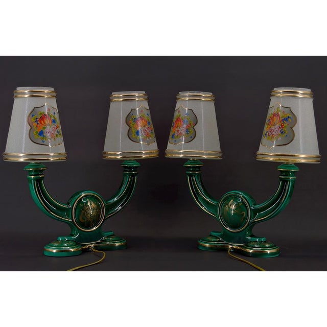Pair of green enameled earthenware lamps enhanced with gilding, depicting bouquets of flowers. Each lamp has 2 arms, and...