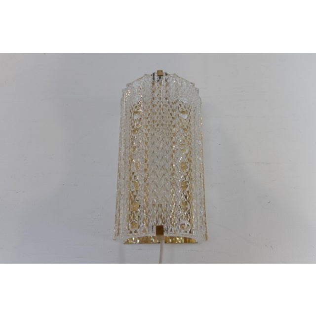 Danish Mid-Century Glass and Brass Sconce, 1960s. Lovely Scandinavian Mid-Century Modern brass wall light with a clear...
