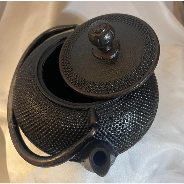 This Japanese teapot, specifically a Nambu Tekki (Nanbu Ironware) cast iron tetsubin tea kettle, was authentically crafted...