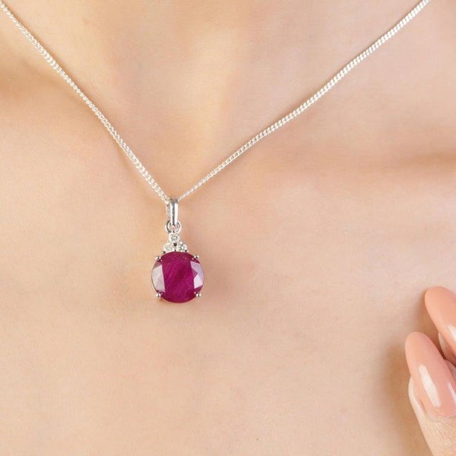 Featuring an 11 mm round-cut ruby weighing 7.2 carats, accented with 2.5 mm diamonds totaling 0.15 carat, this pendant is...
