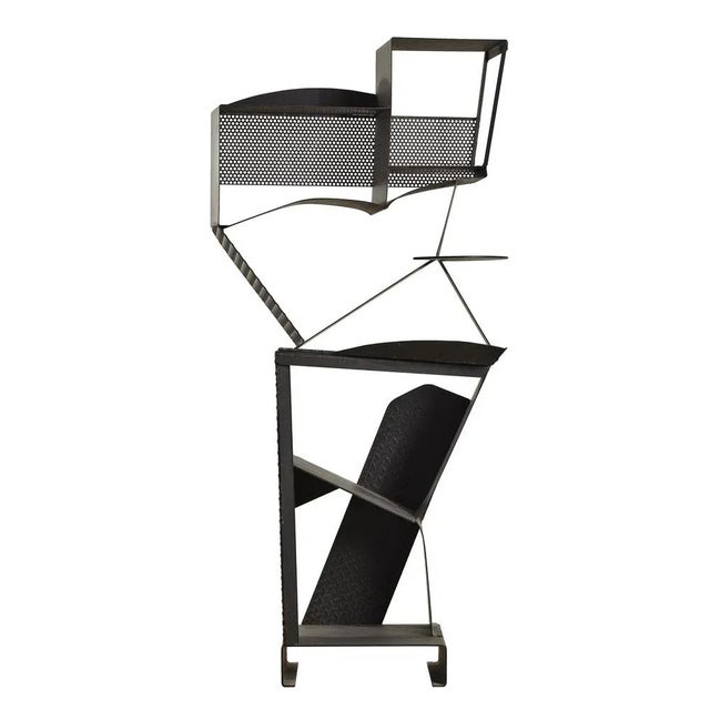 Dilmos bookshop. Shelves and vain containers in smooth or zigrinated iron sheet, which build an almost sculptural figure....