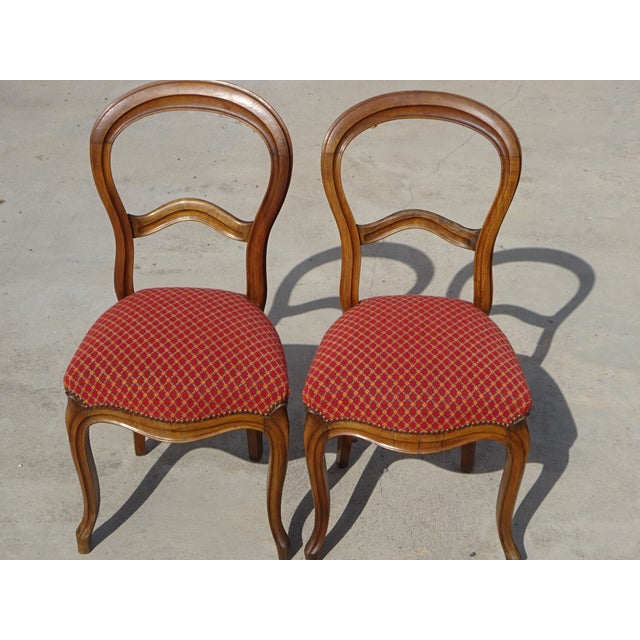 Set of two Louis Philippe style chairs, 19th century. Solid walnut frame. Curved front legs, saber-shaped back. Curved and...