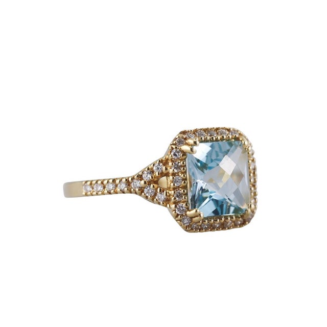 18k Gold and Blue Topaz Ring. The Blue Topaz gemstone features broad geometric facets that catch and reflect light. A...