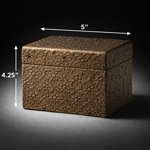 A richly textured vintage metal-clad jewelry or trinket box featuring an intricate all-over embossed floral motif in aged...