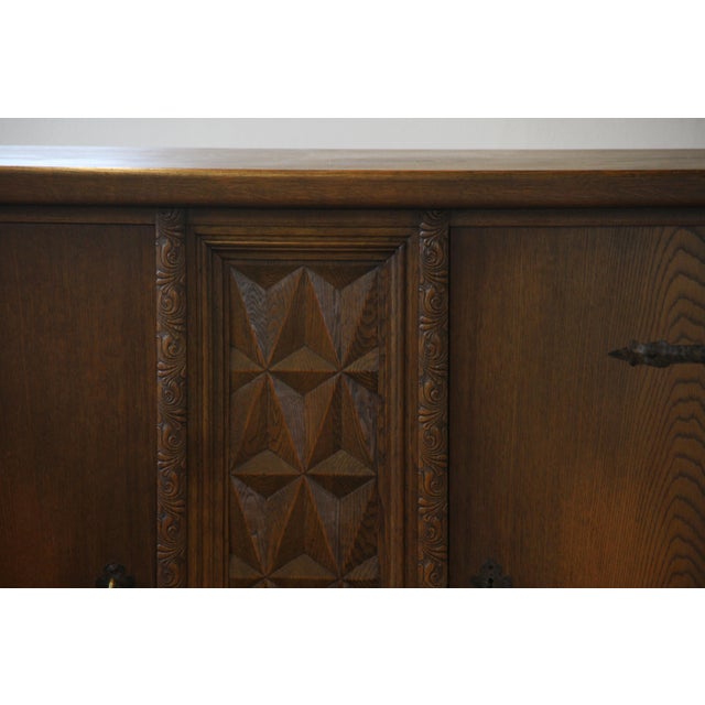 This beautifully crafted cabinet is made from dark-stained oak in the style of Henning Kjærnulf, blending Baroque and...