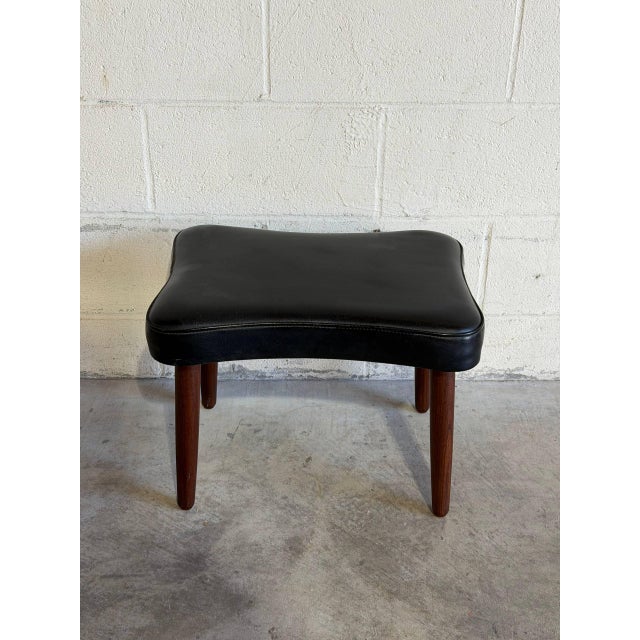 This minimalist ottoman features a gently contoured rectangular top raised on slender round legs. Its low profile offers...