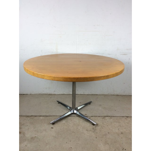 This mid century modern dining table features round butcher block top, original maple finish, and chrome pedestal base.