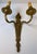 A beautiful and highly decorative pair of French Louis XVI style bronze two-light wall sconces, exhibiting the refined...
