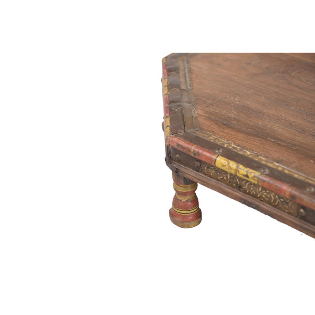 Vintage Indian Teakwood Bajot Table, the octagonal top centered with a brass medallion, and a red and yellow painted top...