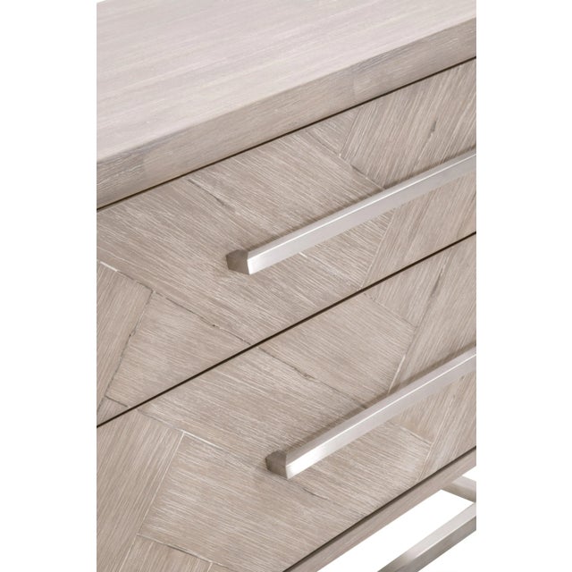 This nightstand features clean lines with a sleek brushed stainless steel base and long, slender matching handles. Its...