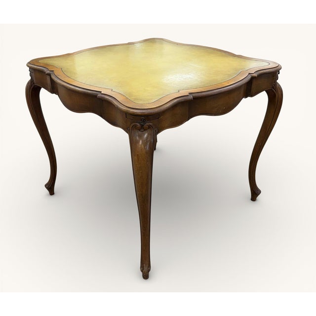 Mid-Century Weiman Heirloom Leather Top Game or Card Table. Framed in a walnut-tone wood, the table features cabriole legs...