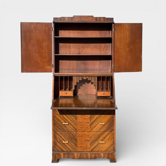 Art Deco secretary desk with a drop-front writing surface and chevron-patterned veneer, circa 1930s. This tall,...