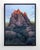 This oil painting depicts a solitary figure standing before a majestic rock formation, bathed in warm, golden light as the...
